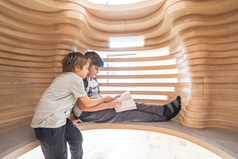 This modern school features custom-designed reading pods made from wood and a felt cushion. #FurnitureDesign #ReadingPod #SchoolDesign