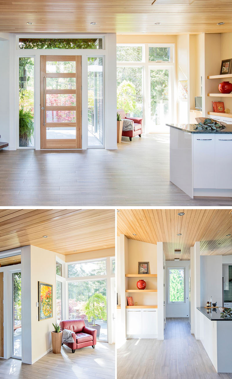 Inside this modern house, there's a small sitting area to the side of the front door, that has a shelving unit, a door to the front sun deck, and doors on either side of the shelf that lead to the laundry and the kitchen pantry. #ModernHouse #Entryway #InteriorDesign