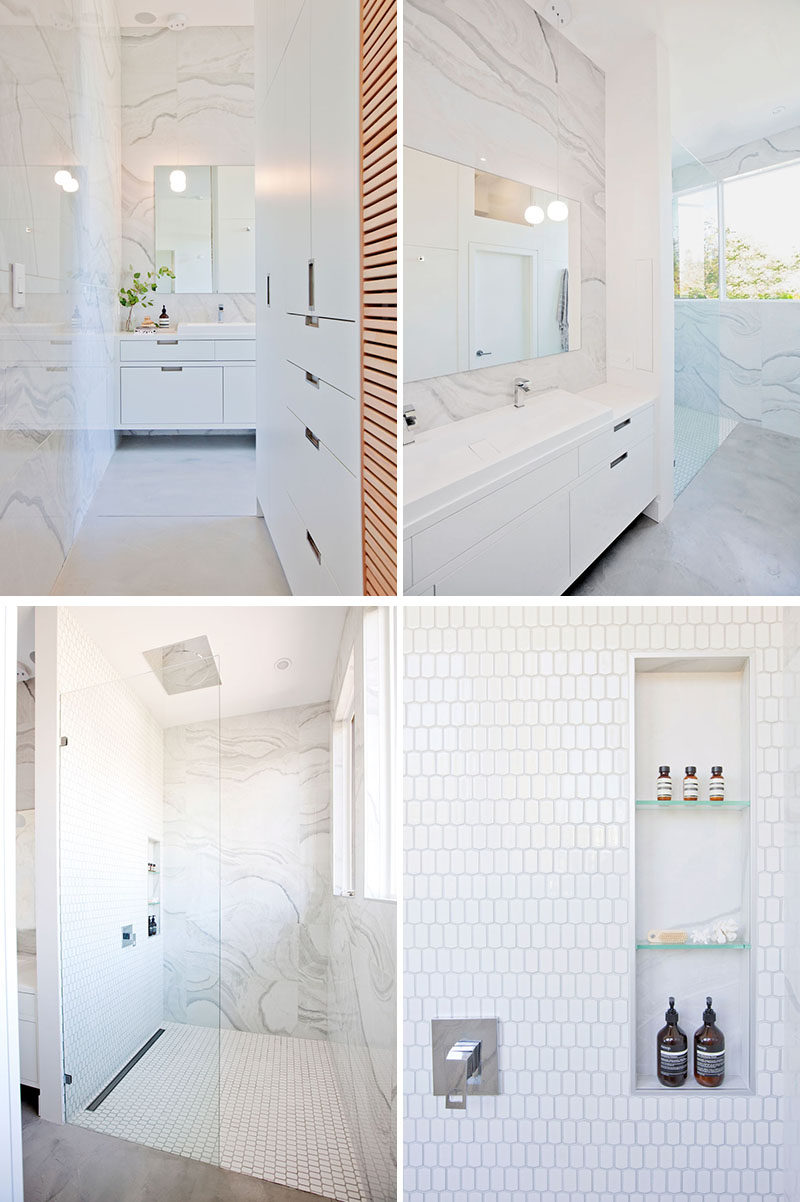 This modern bathroom has been kept bright with the use of light-colored large format tiles and white cabinetry. #ModernBathroom #WhiteBathroom #BathroomDesign