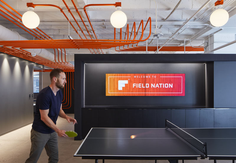 Studio BV have designed the Field Nation offices that were inspired by a circuit board and features orange conduit piping throughout, guiding people to the various areas of the office. #InteriorDesign #OfficeDesign #DesignAccent