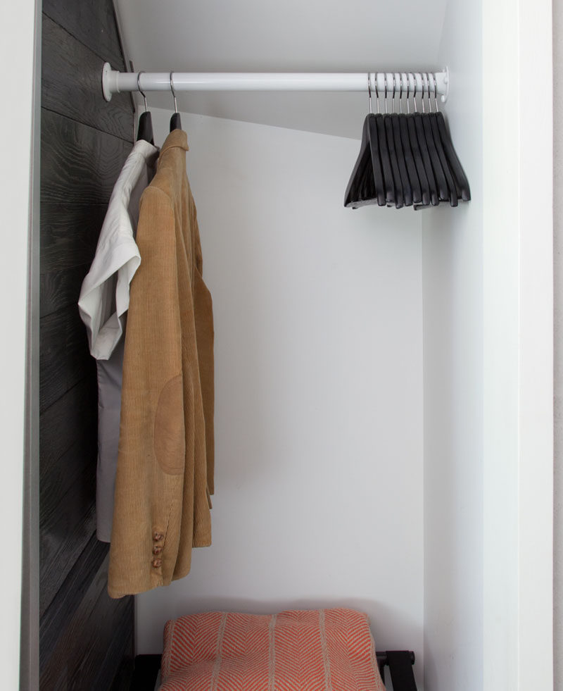This small bedroom has a simple yet efficient open closet for hanging clothes. #OpenCloset