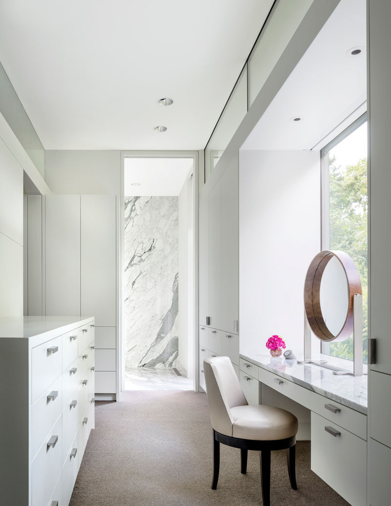 This modern master closet has plenty of storage and a vanity that looks out to the garden. #MasterCloset #ClosetDesign