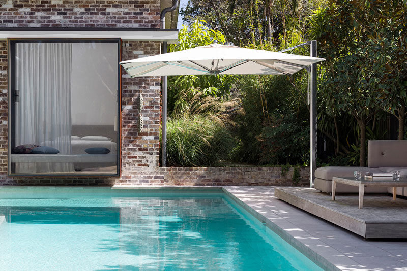 This Australian house has a swimming pool that meets the house and a deck that's located in the shade of the trees. #SwimmingPool