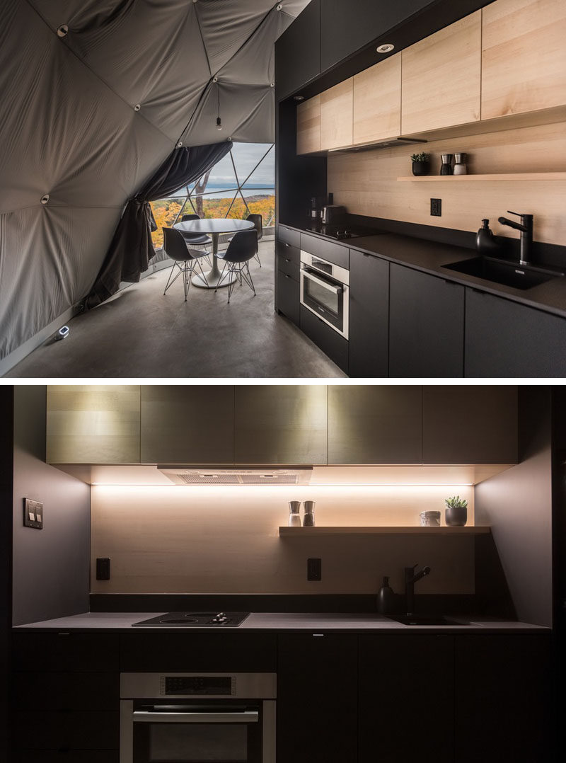 Stepping inside this modern dome, there's radiant concrete floors to keep the interiors warm, and a kitchen with matte black and light wood cabinetry. #BlackAndWoodKitchen #KitchenDesign