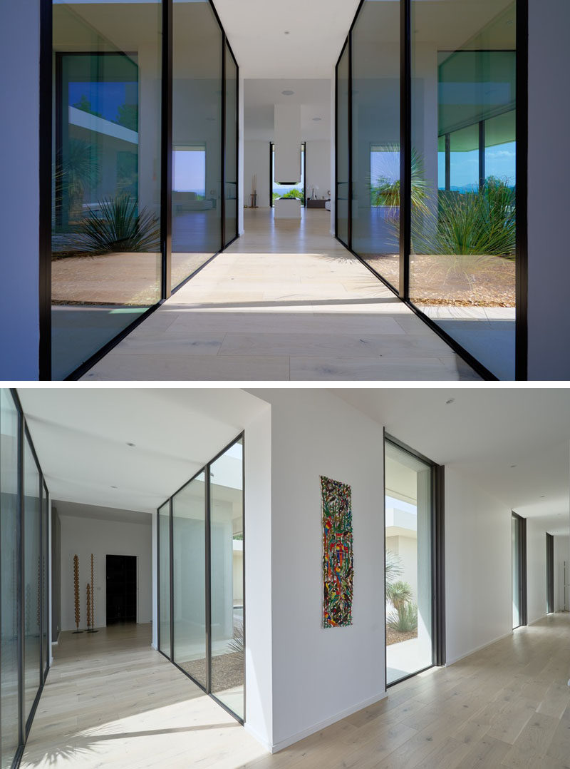 This modern hallway has floor-to-ceiling windows that provide a view of the garden and plenty of natural light. #Hallway #FloorToCeilingWindows