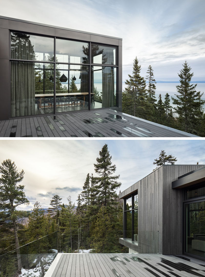 The social areas of this modern house open up to a deck with a glass railing, so that the home owners can enjoy uninterrupted scenic views. #ModernHouse #Deck #Windows