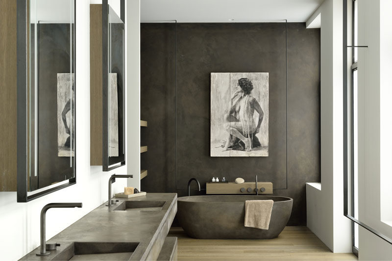 In this master bathroom, a double vanity with built-in sinks complements the freestanding bathtub. #BathroomDesign