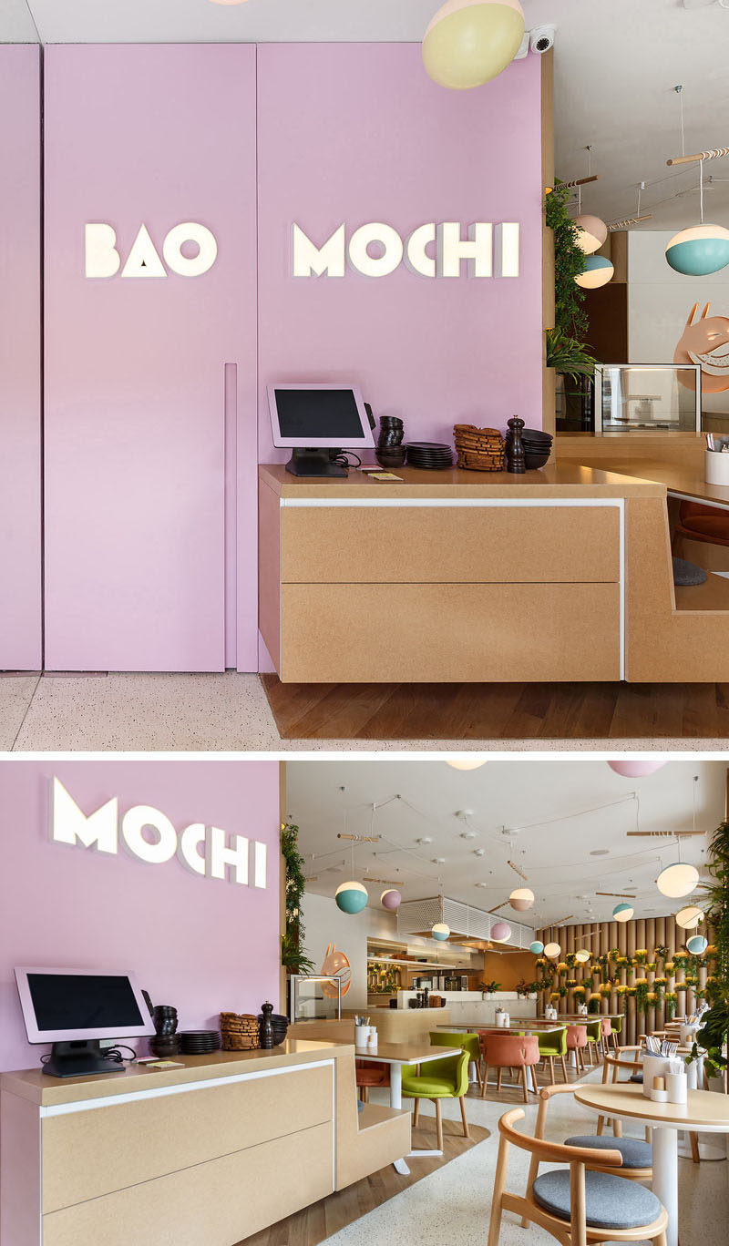 A soft purple accent wall with the restaurants logo greets customers as they arrive. #RestaurantDesign #Signage #InteriorDesign