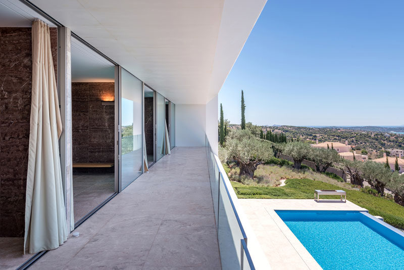 The bedrooms and bathrooms of this modern house all open up to a covered balcony that overlooks the swimming pool below. #Balcony #Architecture