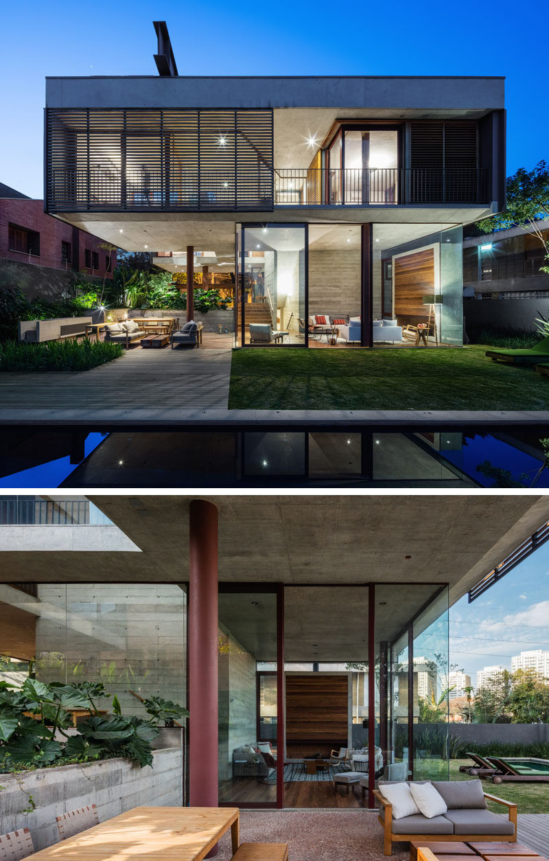 The living room of this modern house opens to the backyard, and there's a cantilevered section of the upper floor that provides shade for the outdoor dining and lounge area. #ModernLivingRoom #ModernHouse #OutdoorLivingRoom