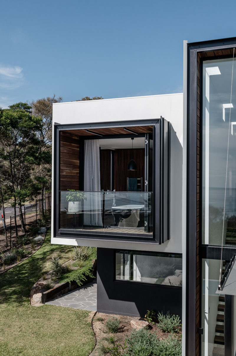 The master bathroom of this modern house opens up to a private balcony that's surrounded by wood. #ModernHouse #Balcony