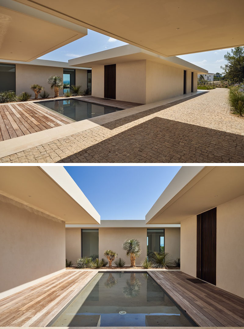 Opposite the carport of this modern house, there's a water feature and a strip of landscaping against the house. #WaterFeature #Landscaping #Architecture