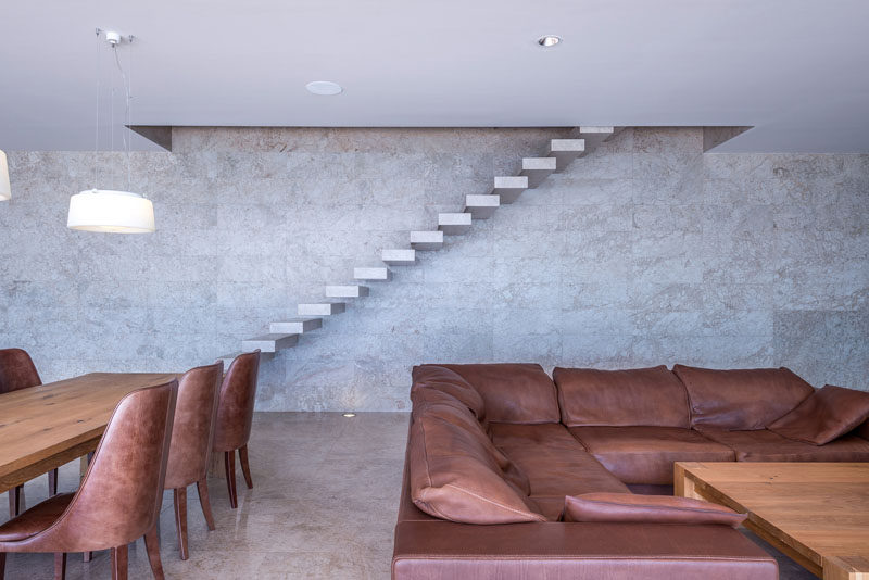 This modern house has floating stairs, located against the wall, that lead to the upper floor of the home. #Stairs #StairDesign #FloatingStairs