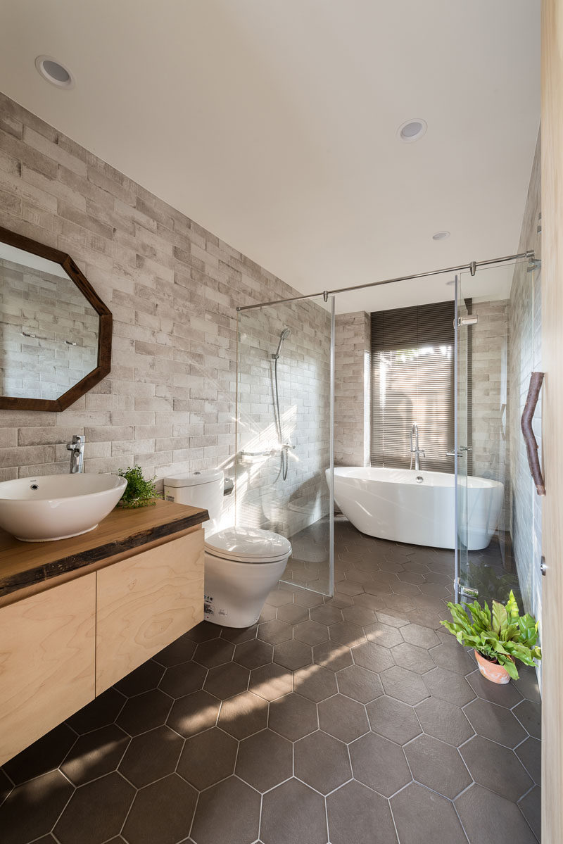 In this modern bathroom, a glass partition separates the shower and freestanding bath from the toilet and vanity area. #BathroomDesign #ModernBathroom