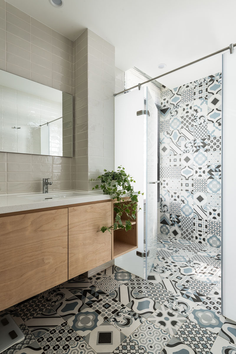 In this modern bathroom, colorful and patterned tiles have been combined with more neutral grey rectangular tiles for a modern appearance. #PatternedTiles #BathroomDesign