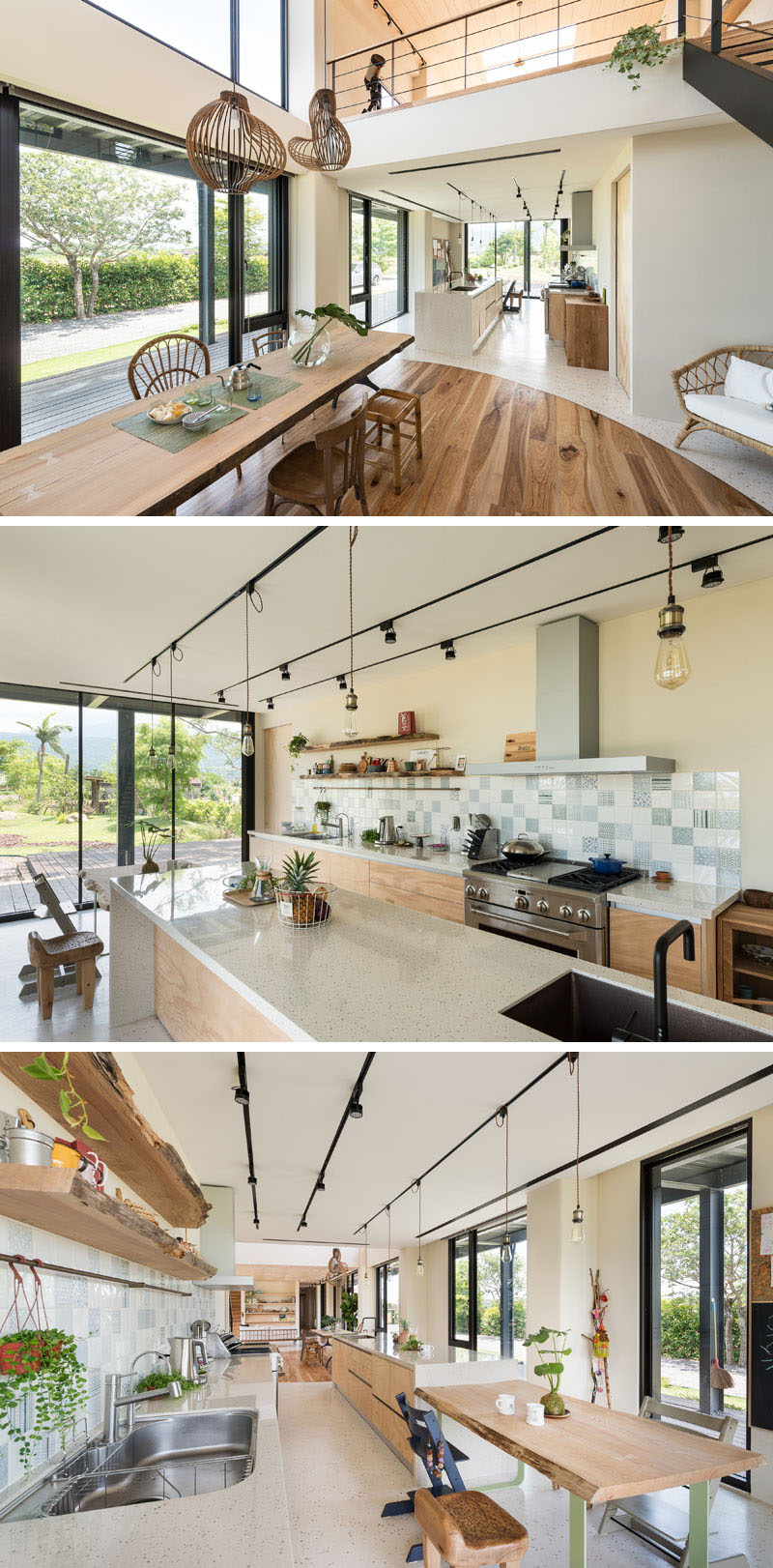 This modern house has kitchen with a long kitchen island that transforms into a casual dining area, while lower cabinets line the wall and raw edge floating shelves sit above the tile backsplash. #KitchenDesign #ModernKitchen