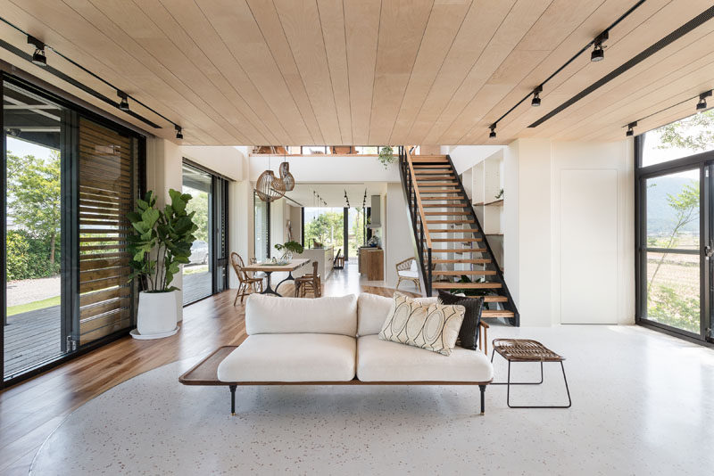 This living room is decorated with minimal furniture, and on either side, windows and sliding glass doors add plenty of natural light. #LivingRoom #InteriorDesign