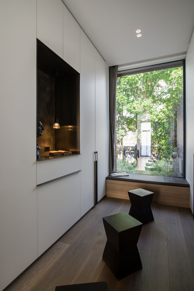 Large windows allow natural light to filter through to the interior of this modern house, and by this window, a simple bench is positioned to take advantage of the garden views. #WindowSeat #Window