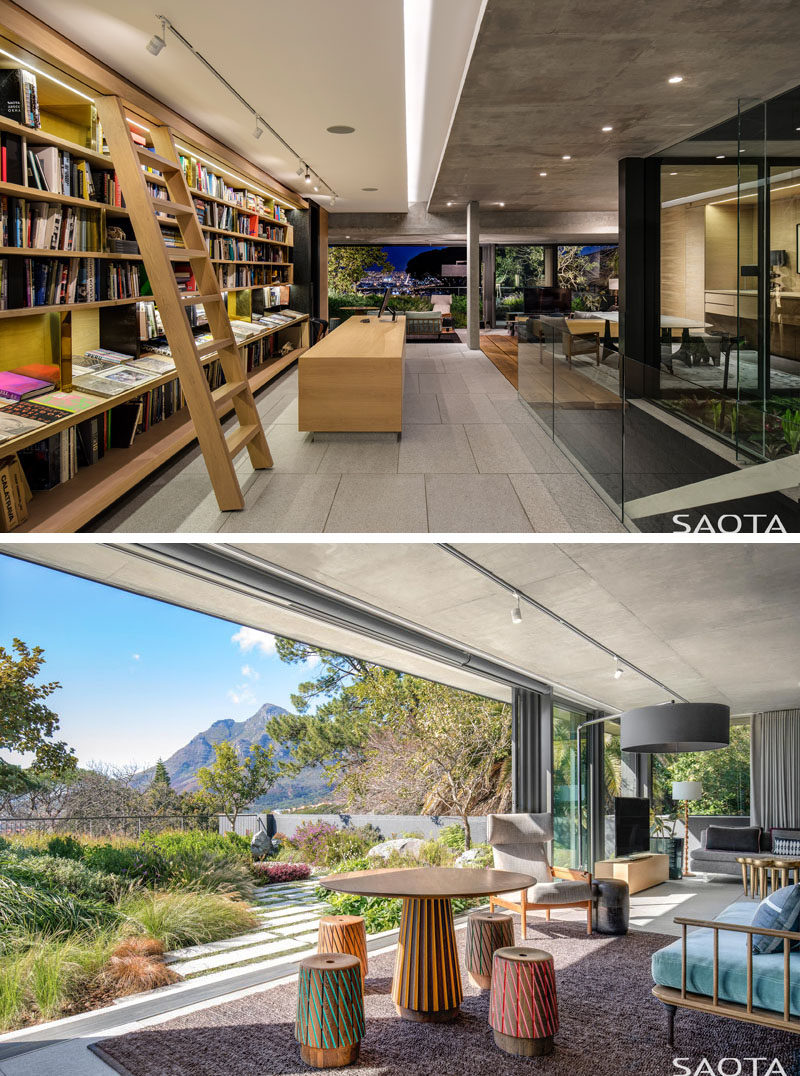 This modern house features a library that has a bookshelf that runs floor-to-ceiling and wall-to-wall, and a rolling library ladder for reaching the high shelves. At the end of the library, there's a lounge that opens to a landscaped garden. #Library #Bookshelf #Lounge #Garden #Landscaping