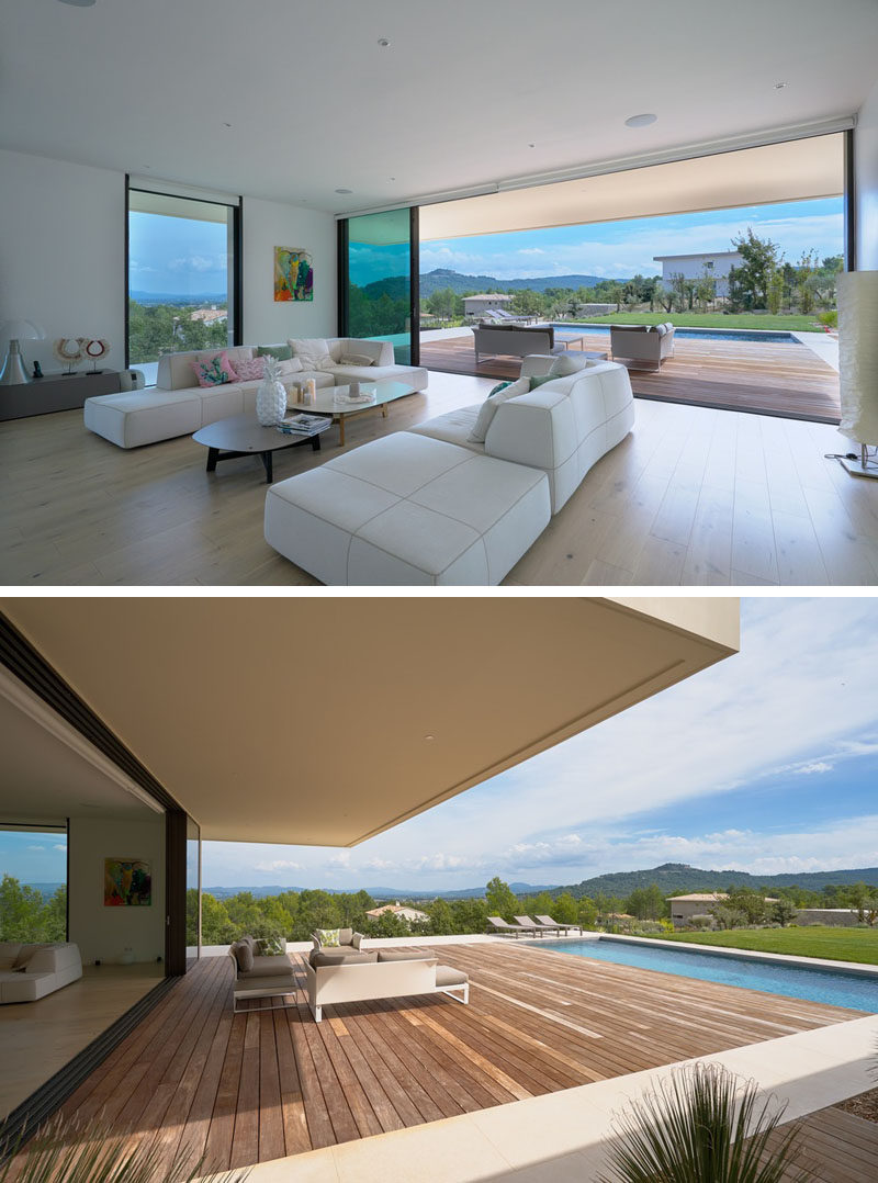 In this modern living room, a wall of glass retracts to open the interior to the deck and swimming pool outside, creating an indoor/outdoor living atmosphere. #LivingRoom #Deck #SwimmingPool