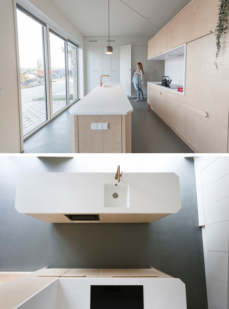 This modern loft apartment has a subtle palette of birch wood and white Corian. There's a bathroom, storage room, kitchen, raised living room, and a lofted bedroom. #InteriorDesign #ApartmentDesign #Loft