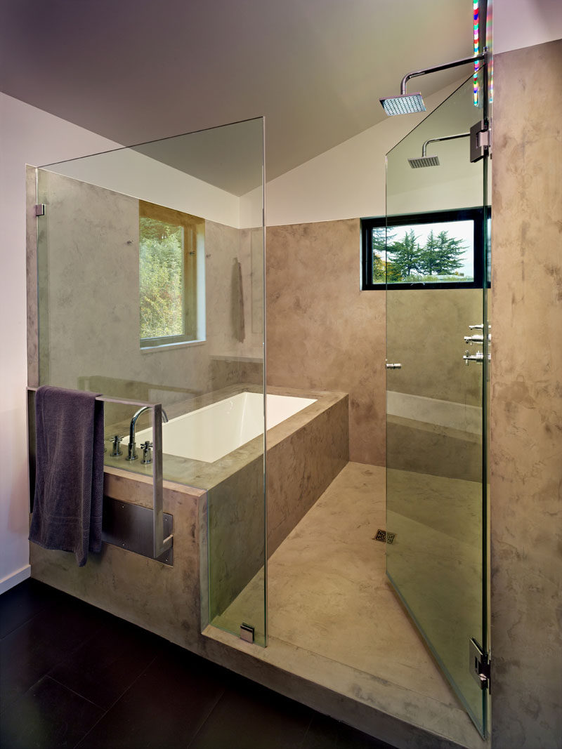 This modern master bathroom incorporates the shower and built-in bathtub into a frameless glass enclosed wet room. #MasterBathroom #BathroomDesign #ModernBathroom