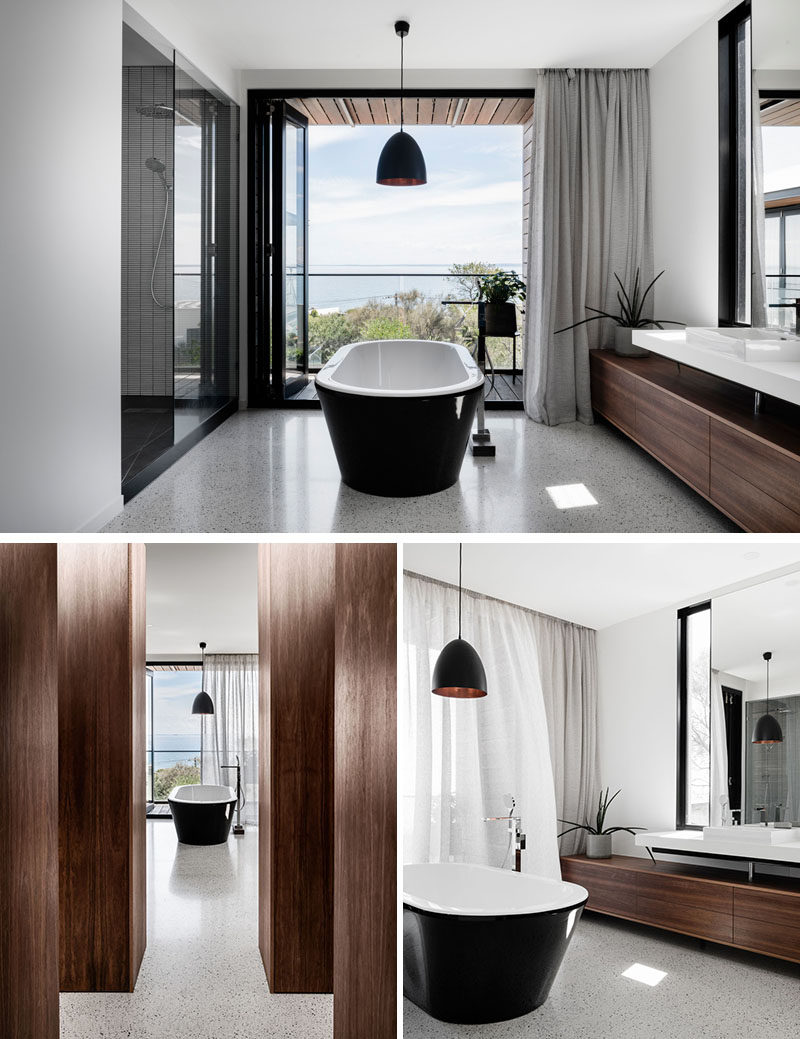 In this modern master bathroom, the freestanding bathtub has been positioned to make the most of the views, and it also separates the shower area from the vanity. #MasterBathroom #BathroomDesign