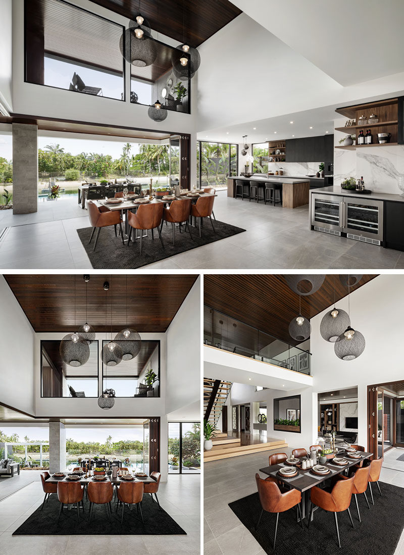 A modern dining area with a double height dark wood ceiling.