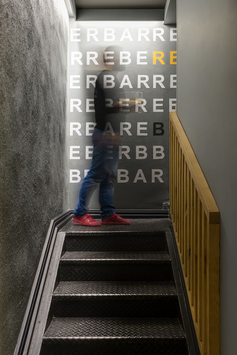 This modern restaurant has black stairs with a wood handrail that lead from the street up to the dining areas. #Stairs #RestaurantDesign