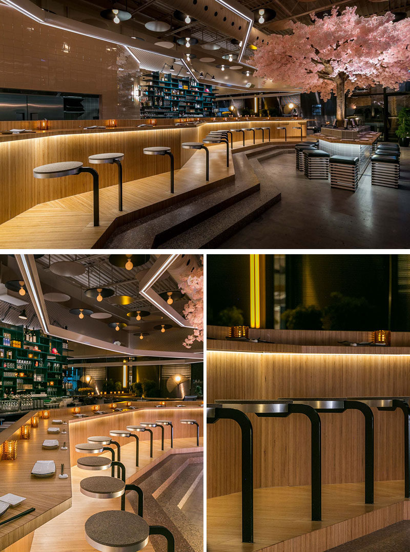 A large bar lined with stools runs the length of this modern restaurant. The European beech bar was prefabricated and transported in six different parts, and is comprised of three distinct stations, set to accommodate the restaurant’s three chefs. #RestaurantDesign #BarDesign #ModernRestaurant