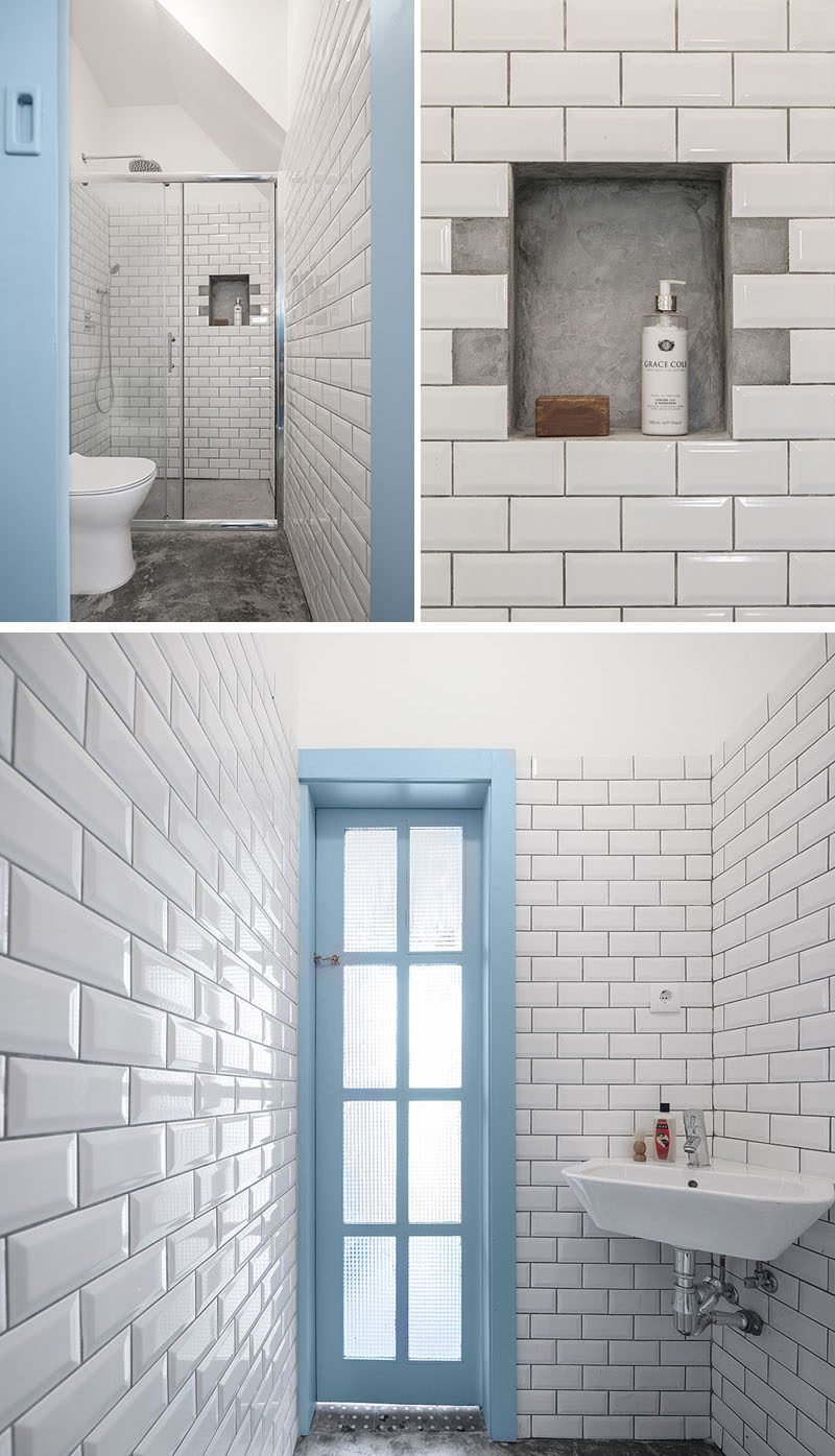 This small and contemporary bathroom features a built-in shelf in the shower that's surrounded by white subway tiles, while the basin is nestled into the corner.