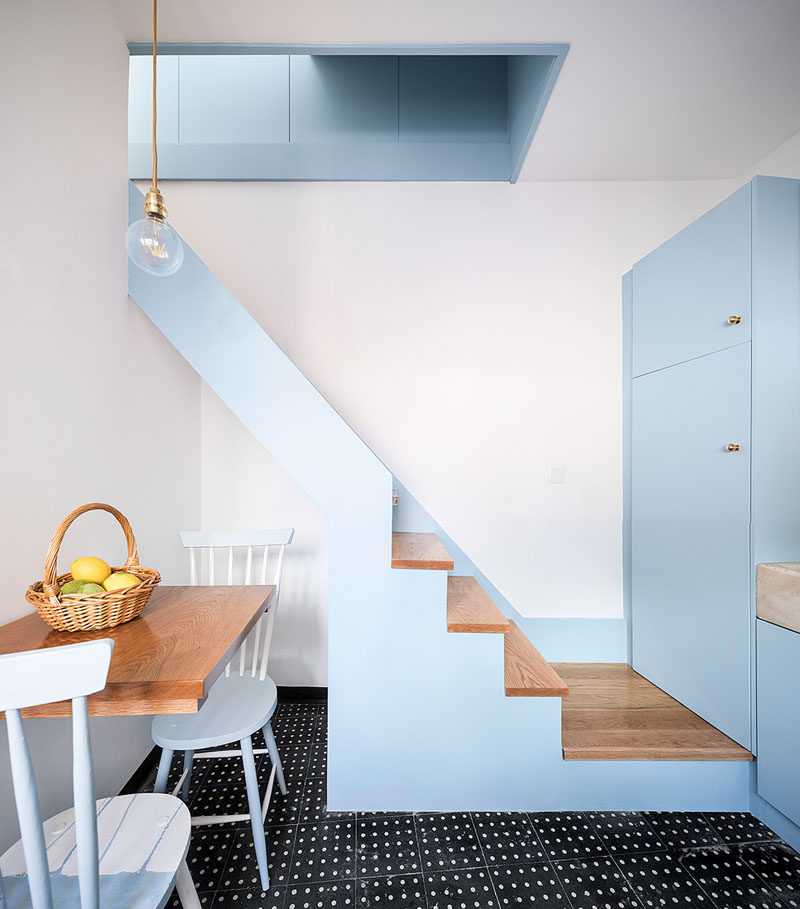 Simple stairs with wood treads run alongside the wall of this tiny house and lead up to the bedroom. #Stairs #StairDesign