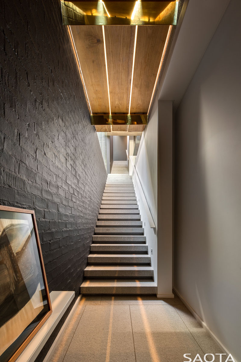 This modern staircase has a black accent wall and overhead lighting. #Stairs #Staircase