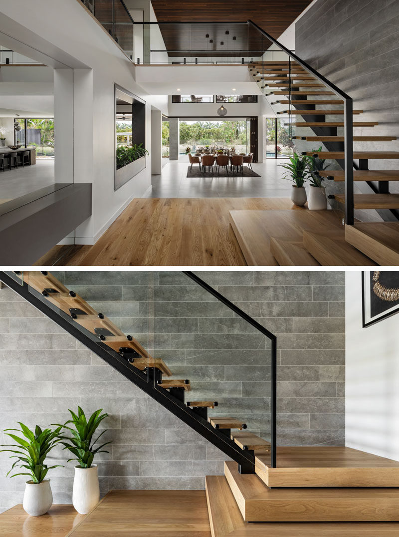 Wood stairs with a steel frame lead up to the second floor against a tiled wall.