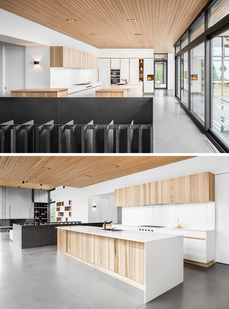 Floor-to-ceiling windows and sliding doors in this modern house, fill the interior with natural light, and in the kitchen, light wood cabinetry and design elements have been paired with white cabinetry for a contemporary appearance. #ModernKitchen #KitchenDesign #Windows