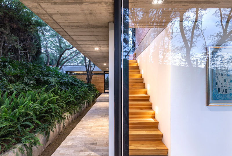 This modern house has a small wood staircase, tucked away a the end of a hallway, that leads to the master bedroom suite. #Stairs #WoodStairs