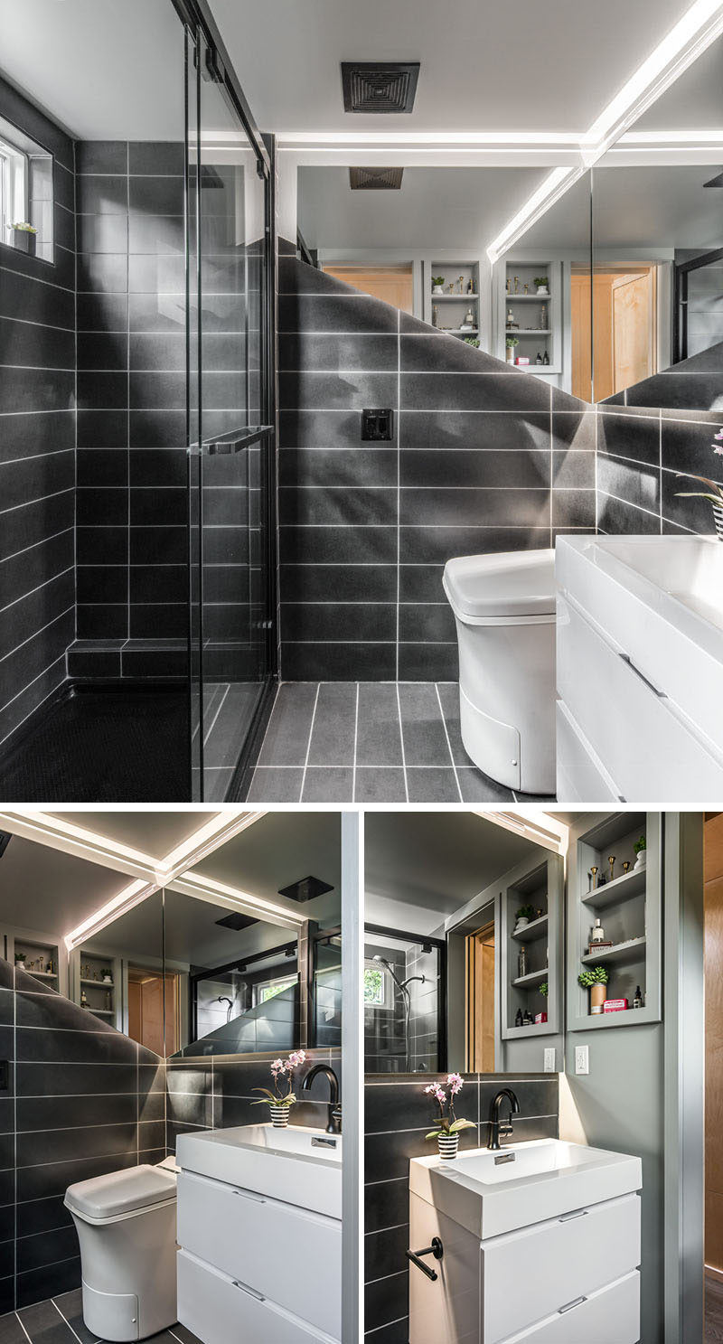 This small and modern bathroom in a tiny house, is covered in custom tile and features a floating mirror with valance LED lighting. There's also a custom floating vanity sink, a Cinderella incinerator toilet, and a 4’x6’ full size shower. #Bathroom #BathroomDesign