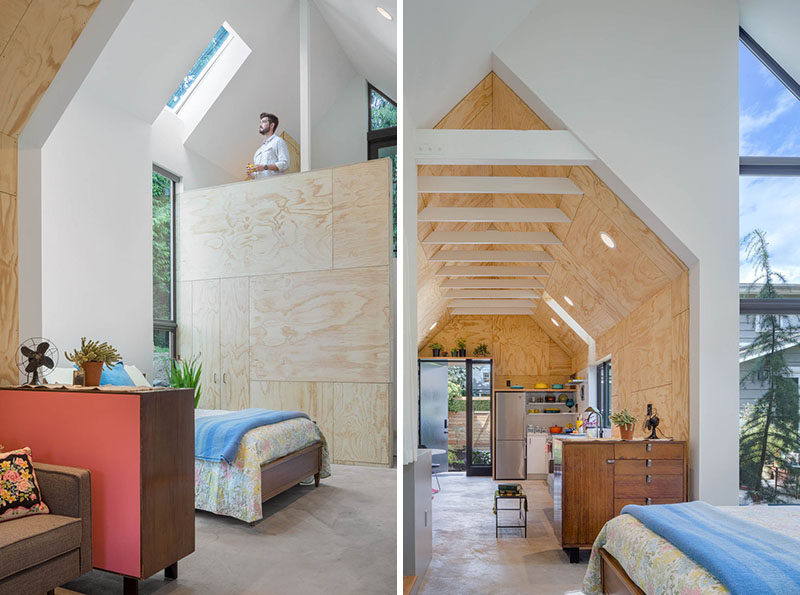 This tiny house features an open floor plan, a high pitched ceiling with exposed white rafters, and a loft area. #TinyHouse #InteriorDesign #Architecture