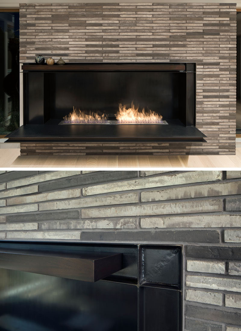 A thin grey brick surrounds the black steel fireplace in this modern living room. #Fireplace #ModernFireplace