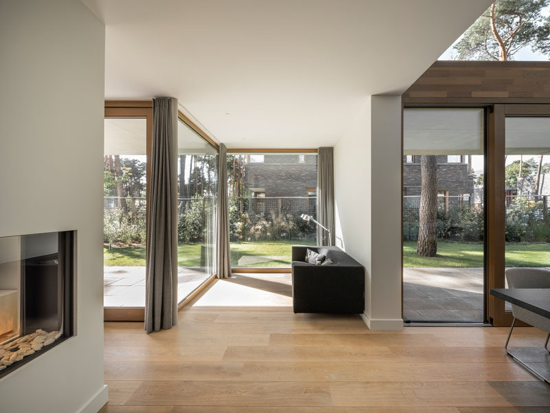 The interior of this modern house is built up of linked volumes of different sizes which create a series of pockets, like this sitting area. #FloorToCeilingWindows #SittingRoom