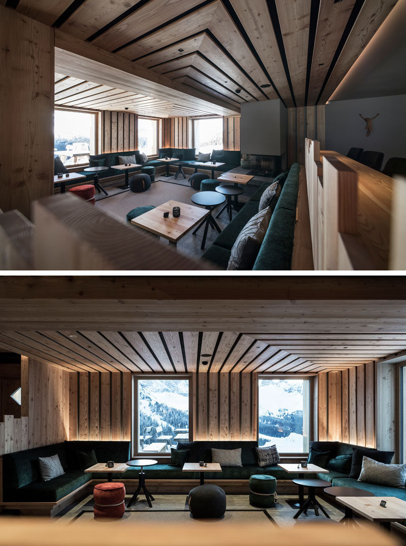 This modern hotel lounge has large windows that frame the view outside, custom built-in seating the wraps around the space, and a fireplace. #HotelDesign #Seating #Fireplace #HotelLounge