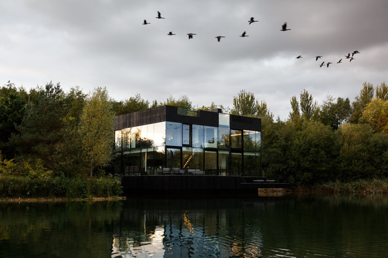 Mecanoo architecten have designed a modern house that sits on a lake in Lechlade, England, and features a walls of glass, enabling expansive views from the home's interior. #Architecture #HouseDesign #LakeHouse