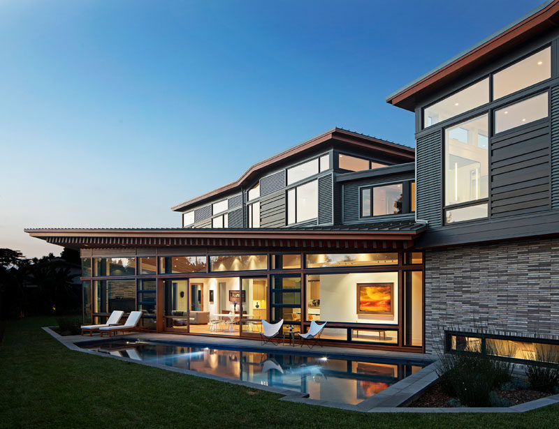 This modern house is comprised of a dramatic series of folded roof planes, and a collage of textured metal and wood exterior surfaces. #ModernHouse #HouseDesign #ModernArchitecture