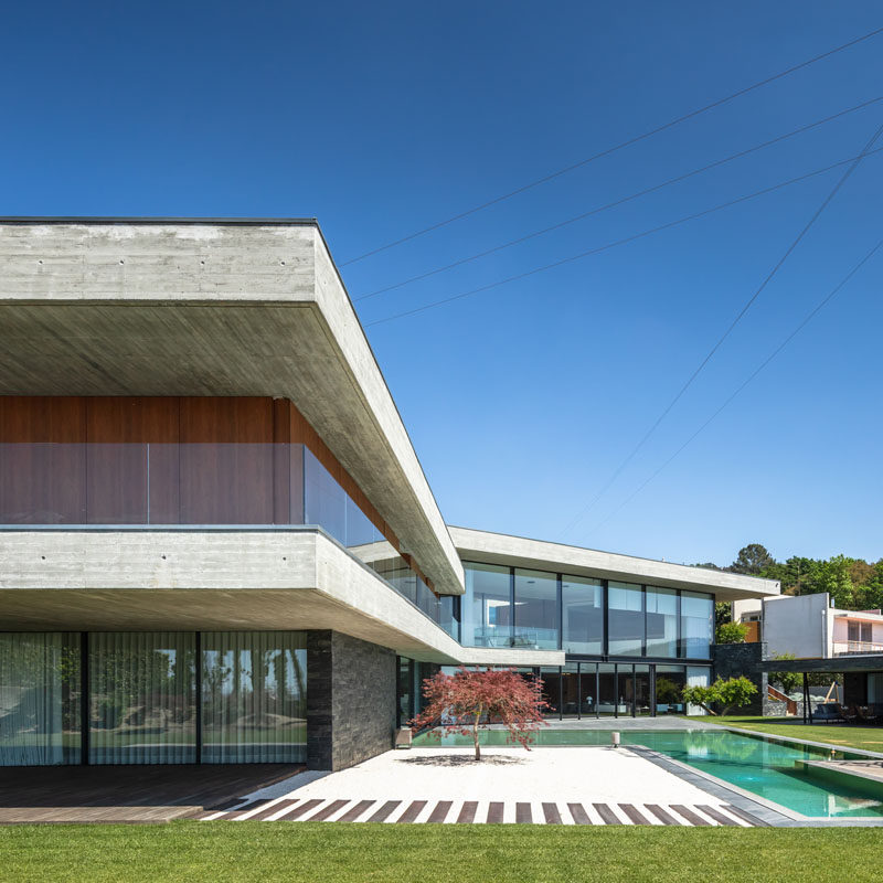 TRAMA Arquitetos have designed the 'Fraiao House', a modern house that sits on a hillside, and was designed in a V shape to take advantage of the sweeping views over the city of Braga, Portugal. #ModernHouse #ModernArchitecture