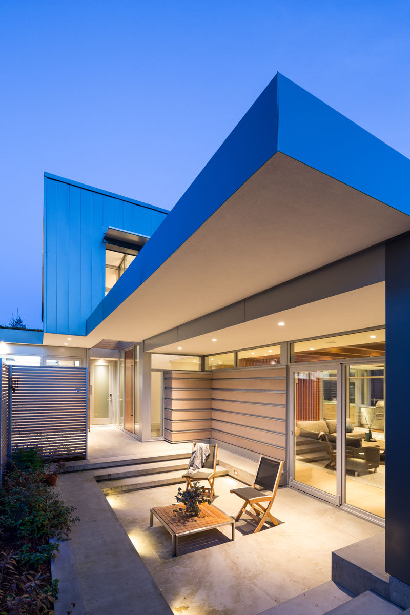 This modern two level home has multiple outdoor areas, like this one that's off to the side of the front door. #ModernHouse #Patio #OutdoorSpace