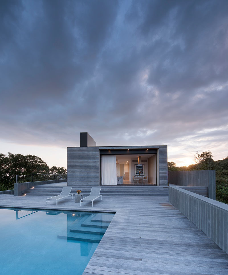 Lightweight curtains line the openings of this modern house and add a softer touch to the wood exterior. #Architecture #InteriorDesign