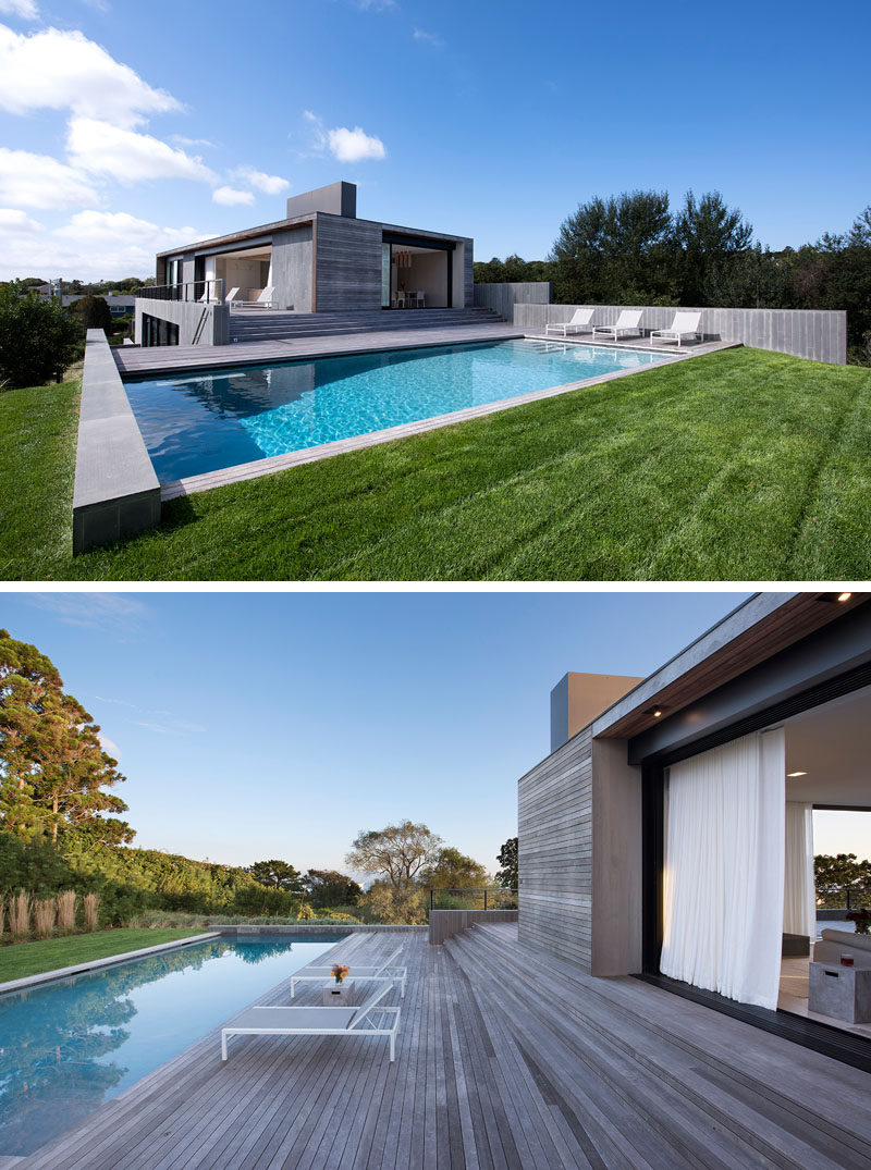 The interior spaces of this modern house open to a deck, which steps down to the swimming pool and grassy lawn. #Deck #ModernHouse #SwimmingPool