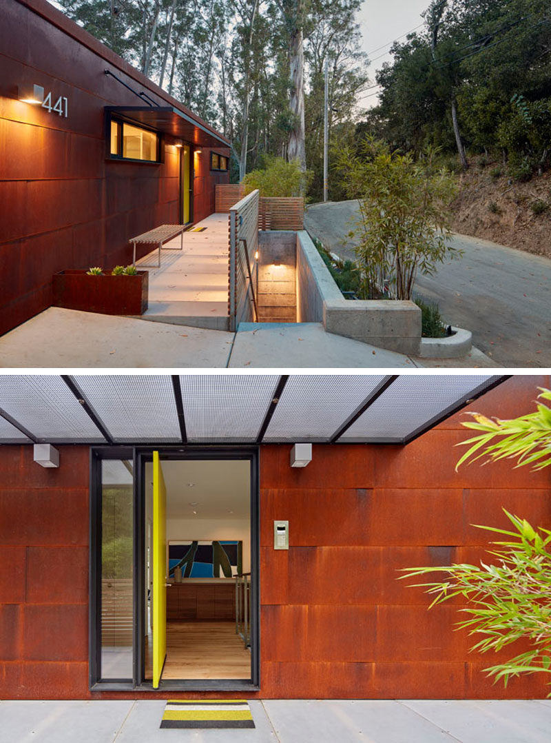 The exterior of this modern house is covered in weathering steel, and over time, the steel will continue to oxidise. A bright yellow pivoting front door welcomes guests to the house. #WeatheringSteel #Siding #Architecture #FrontDoor #PivotingDoor