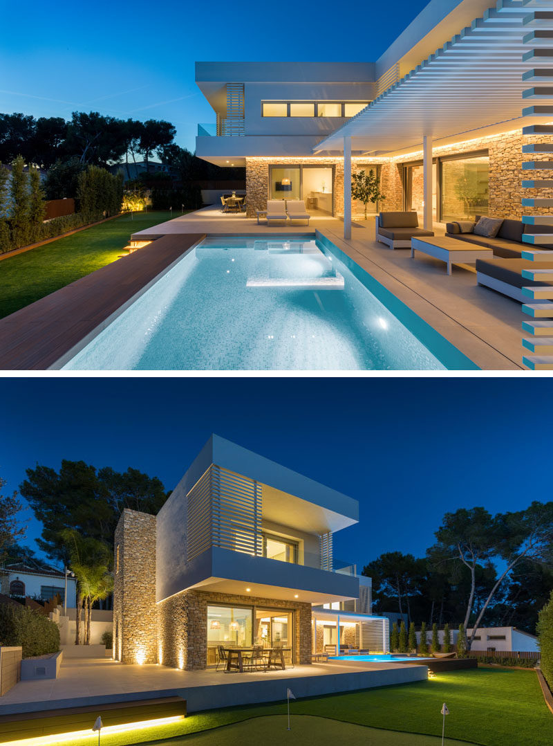 The first floor of this modern house appears to rest on the stone base, and provides cover for some of the outdoor areas of the main floor of the home, like the outdoor dining area. #ModernHouse #ModernArchitecture