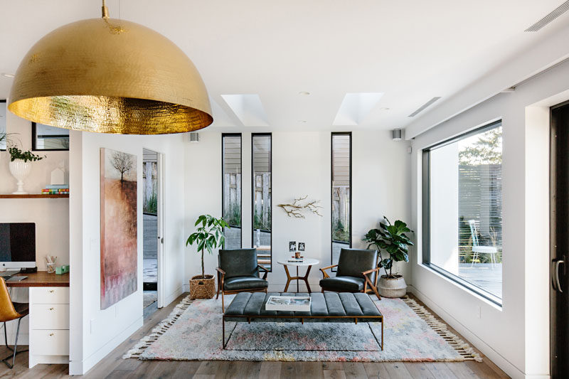 This sitting room is filled with natural light from the large picture window and the tall vertical windows behind the arm chairs. #SittingRoom #LivingRoom #Windows